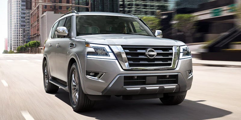 A 2021 Gray Nissan Armada driving down the city streets of a downtown area. - Dann's Discount Auto Sales Visalia, CA